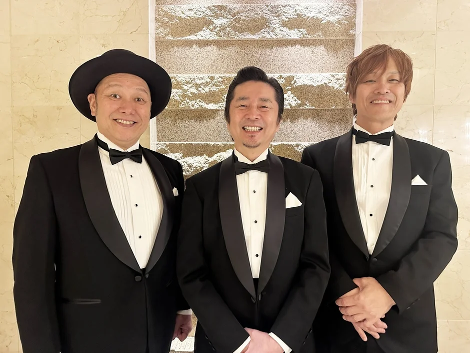 怒髪天のメンバーがタキシード姿で笑顔を見せる様子