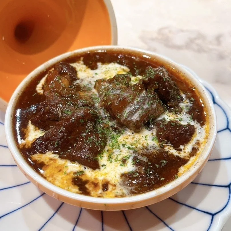 クリームとハーブが添えられた、美味しそうなビーフシチュー