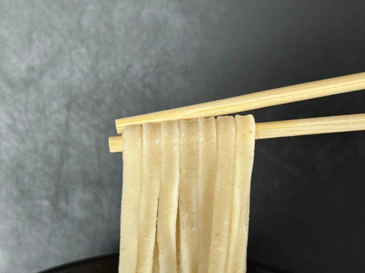 箸で持ち上げられた麺