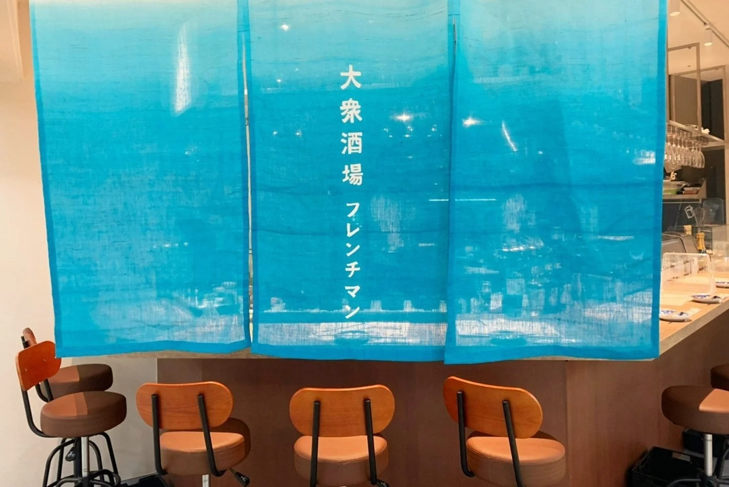 大衆酒場 フレンチマンののれんがかかるバーカウンター