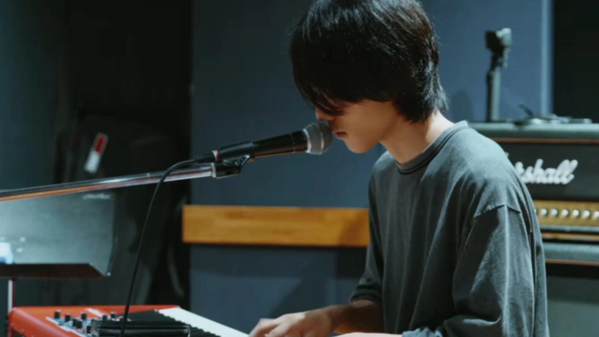 音楽スタジオでキーボードを演奏する男性