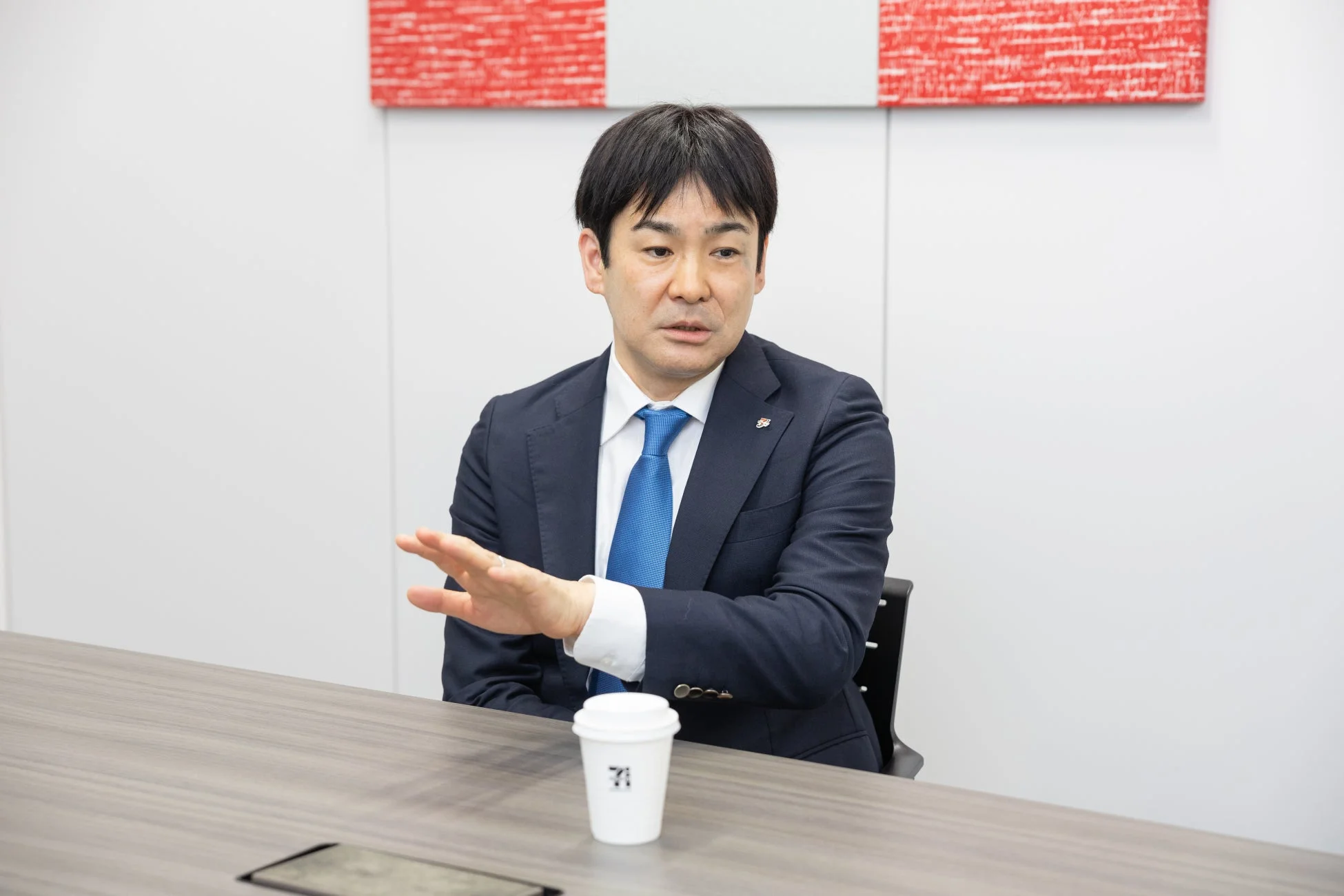 スーツ姿で話す斉藤俊二総括マネジャー