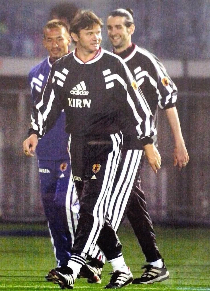 サッカーフィールドを歩くフィリップ・トルシエ氏と選手たち