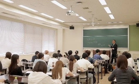 教室で教師が学生たちに講義をしている様子