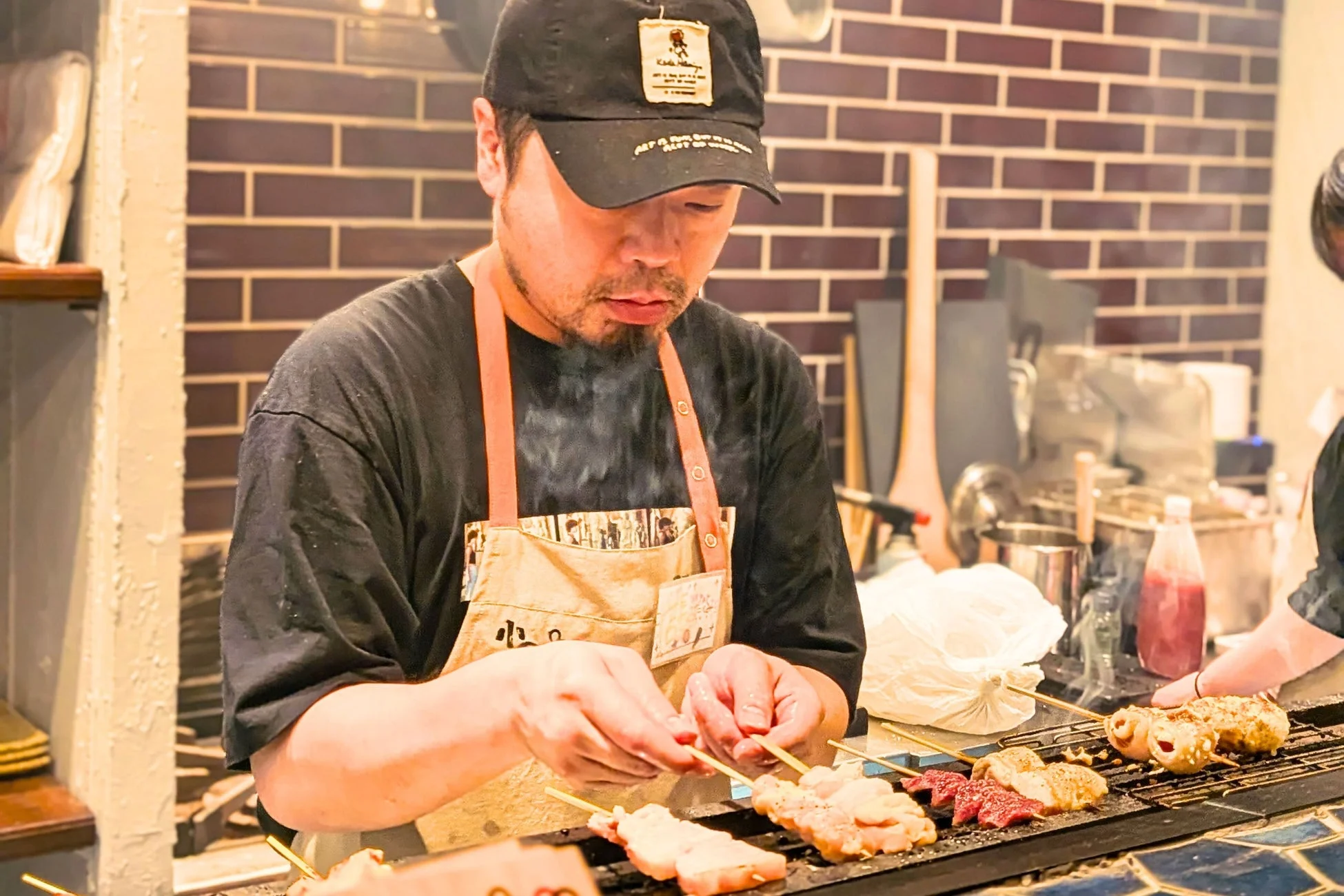 焼き鳥店で炭火焼きを調理する職人