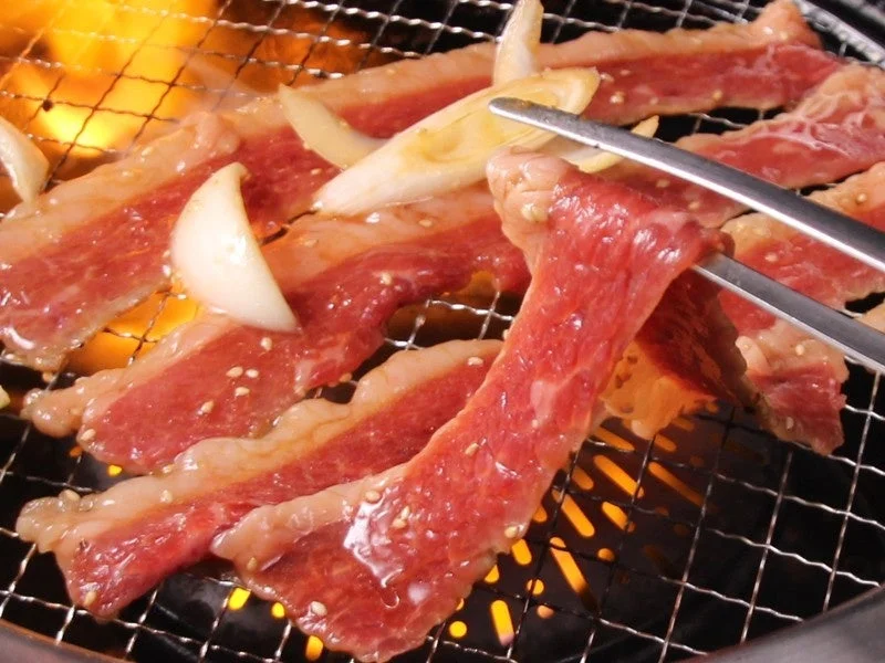 網の上で焼かれる肉と玉ねぎ