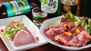 スライスされた肉料理と酒瓶