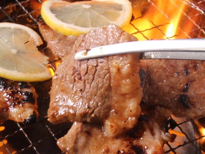 網の上で焼かれる肉とレモン