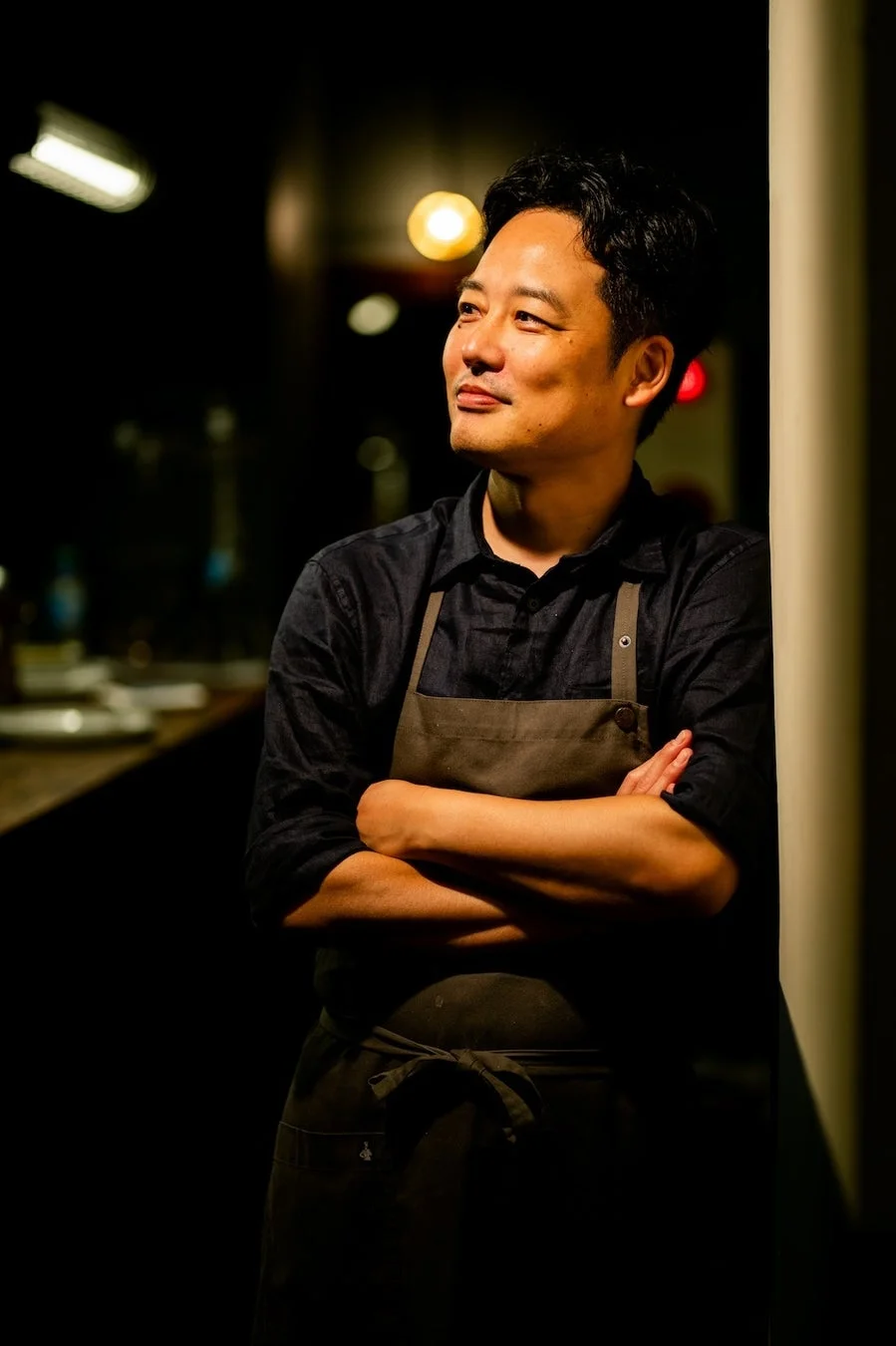 エプロンを着用し微笑む料理人