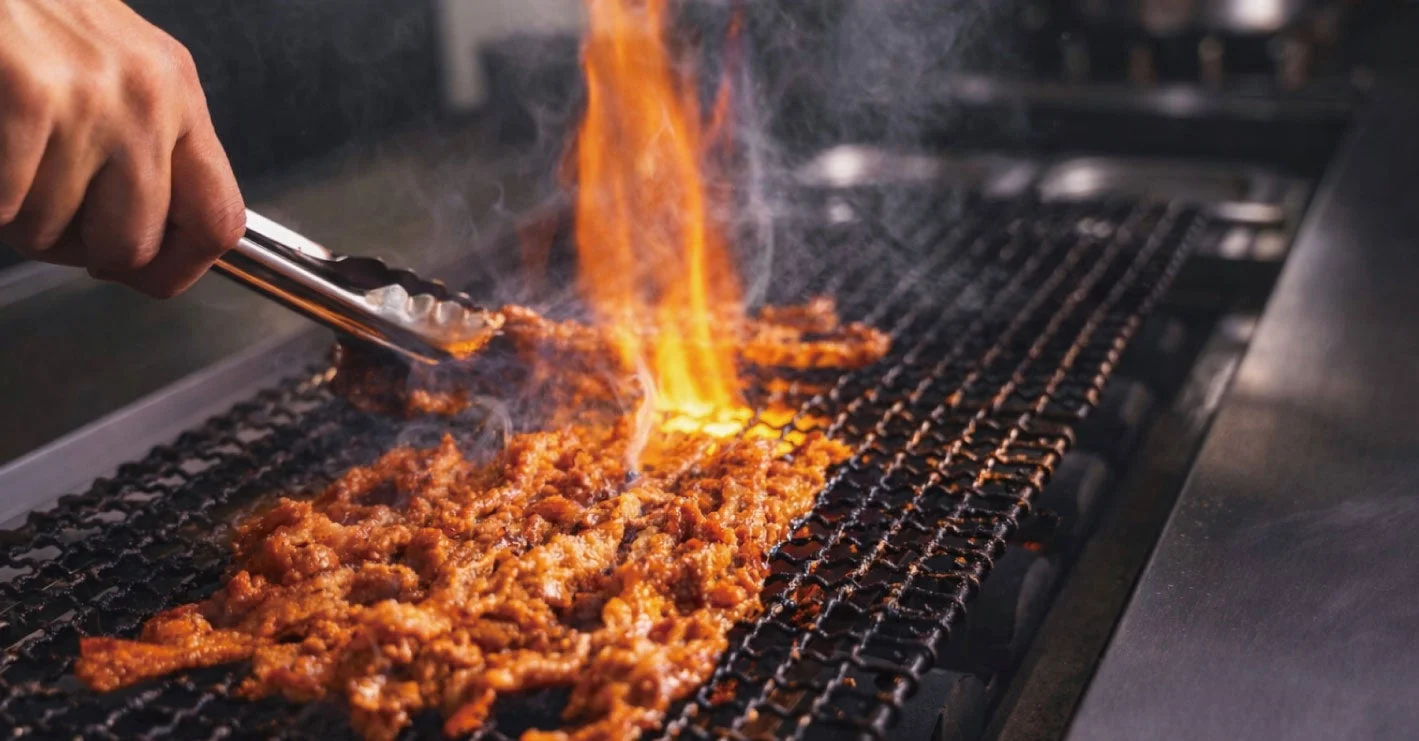 炎を上げて肉が焼かれている様子