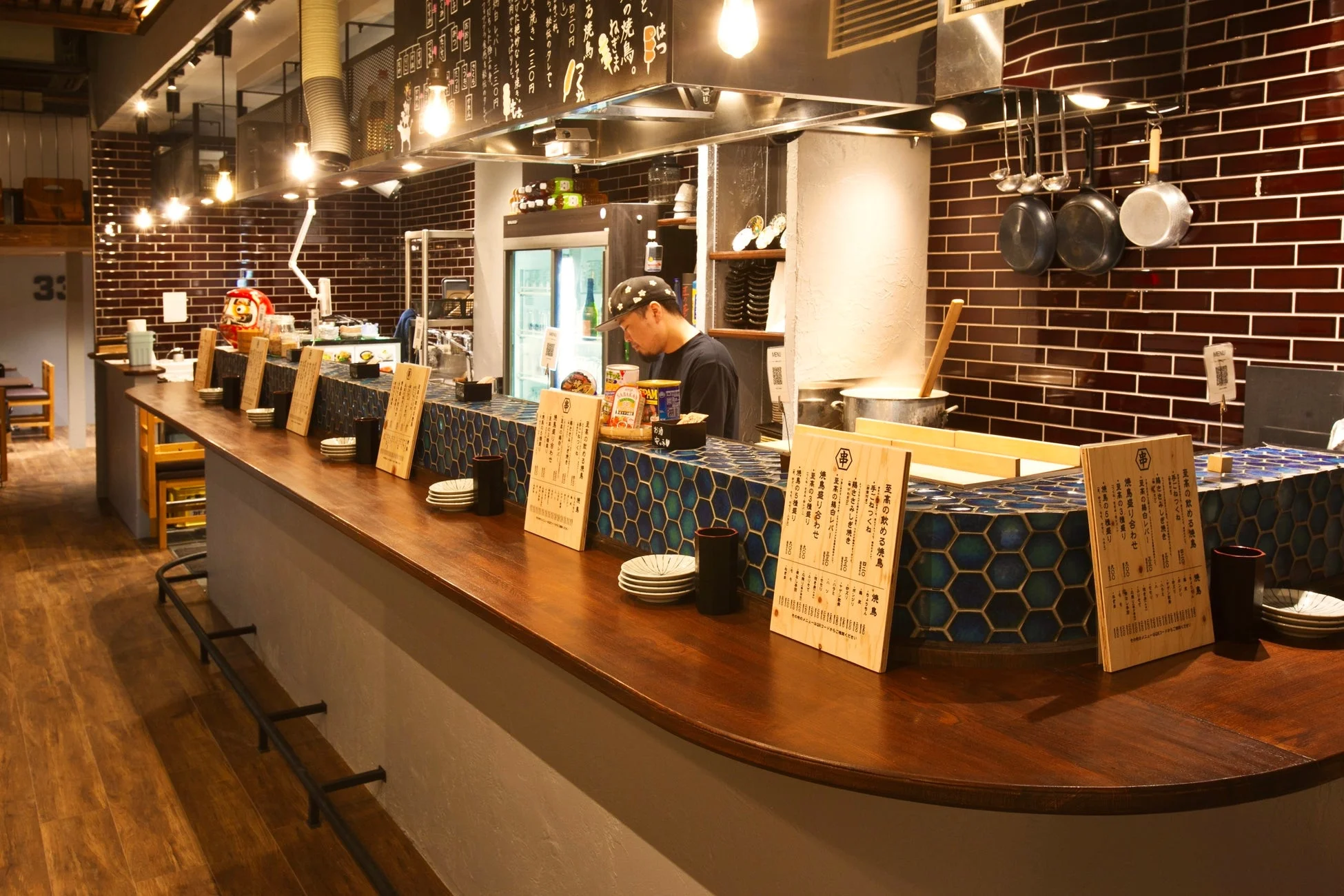 日本の居酒屋の店内風景で、長い木製のカウンター席