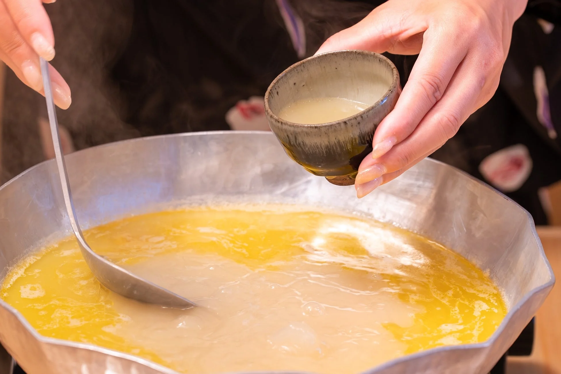 水炊きスープ 鍋からスープをすくう手元