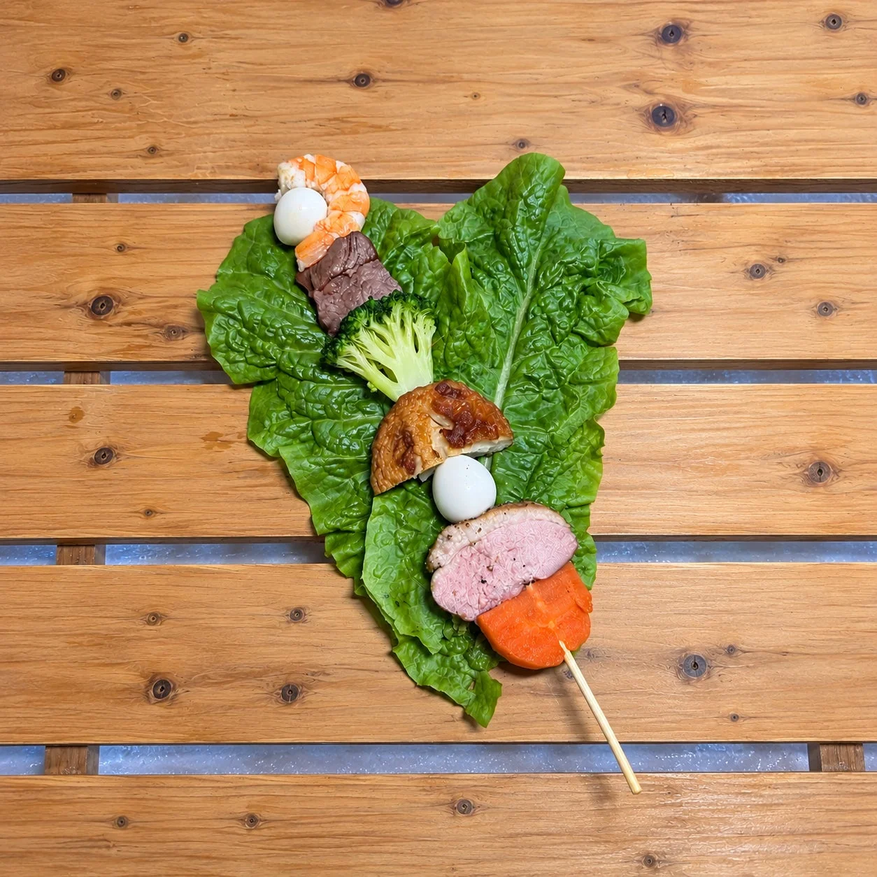 エビ、肉、野菜などが串に刺さった彩り豊かな料理