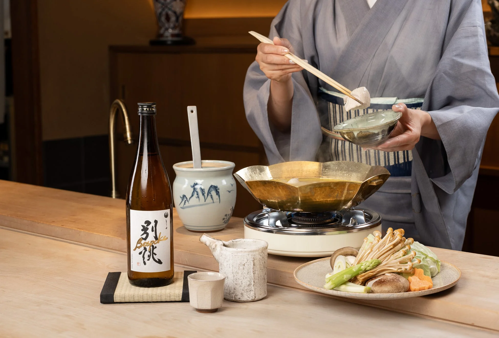 鍋料理と日本酒 カウンター席で鍋料理と日本酒を楽しむ様子