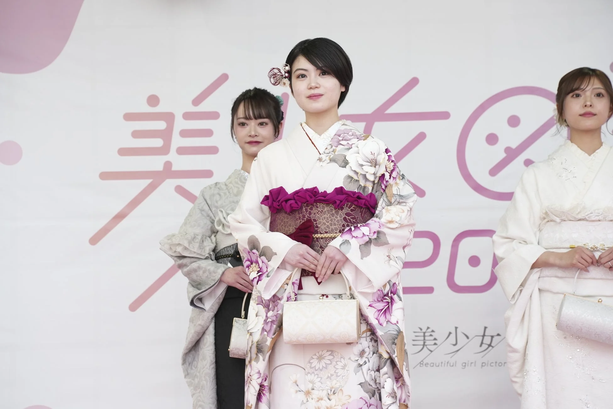 3人の女性が華やかな着物を着てステージに立っています