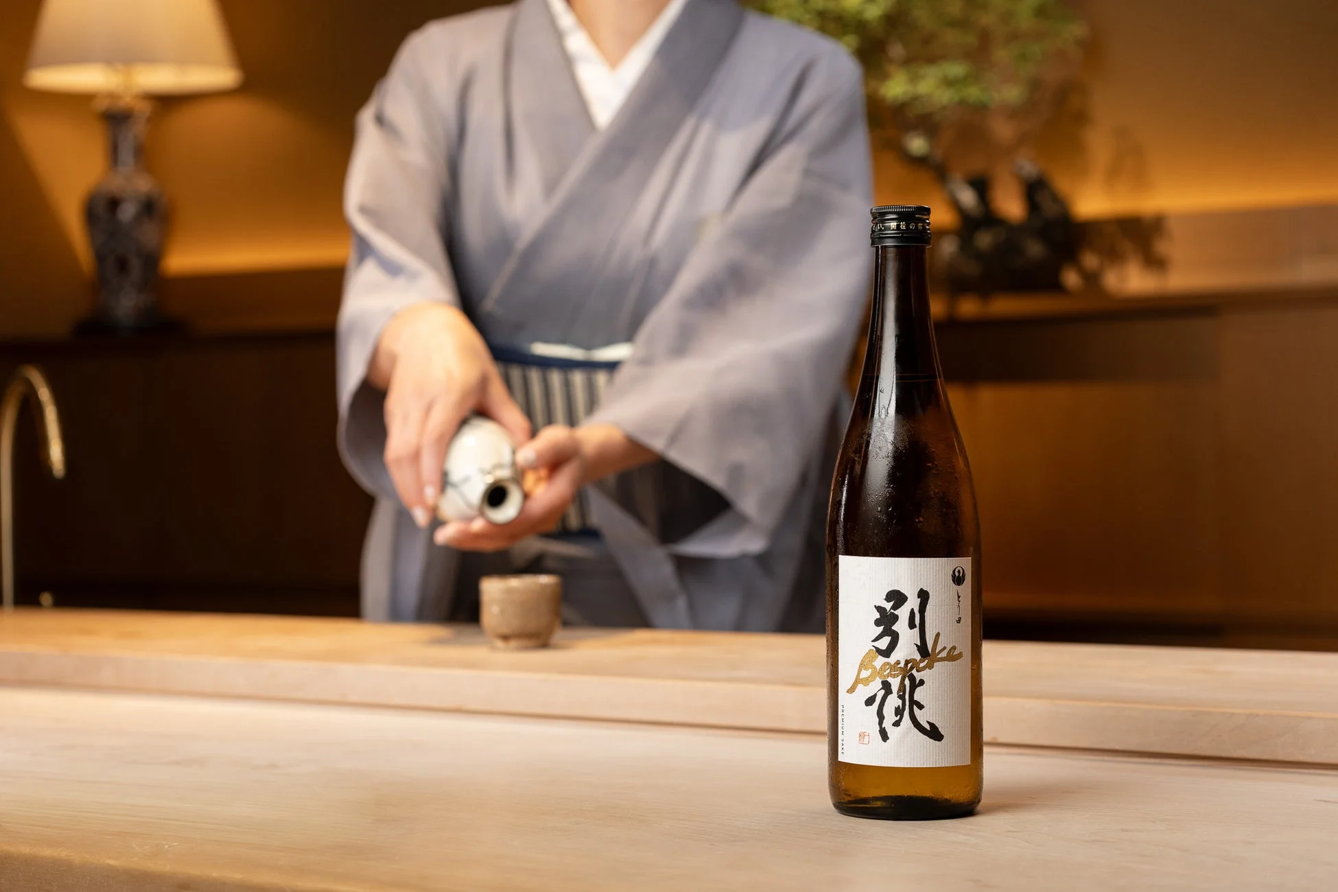 日本酒を注ぐ 日本酒を注ぐ着物姿の人物